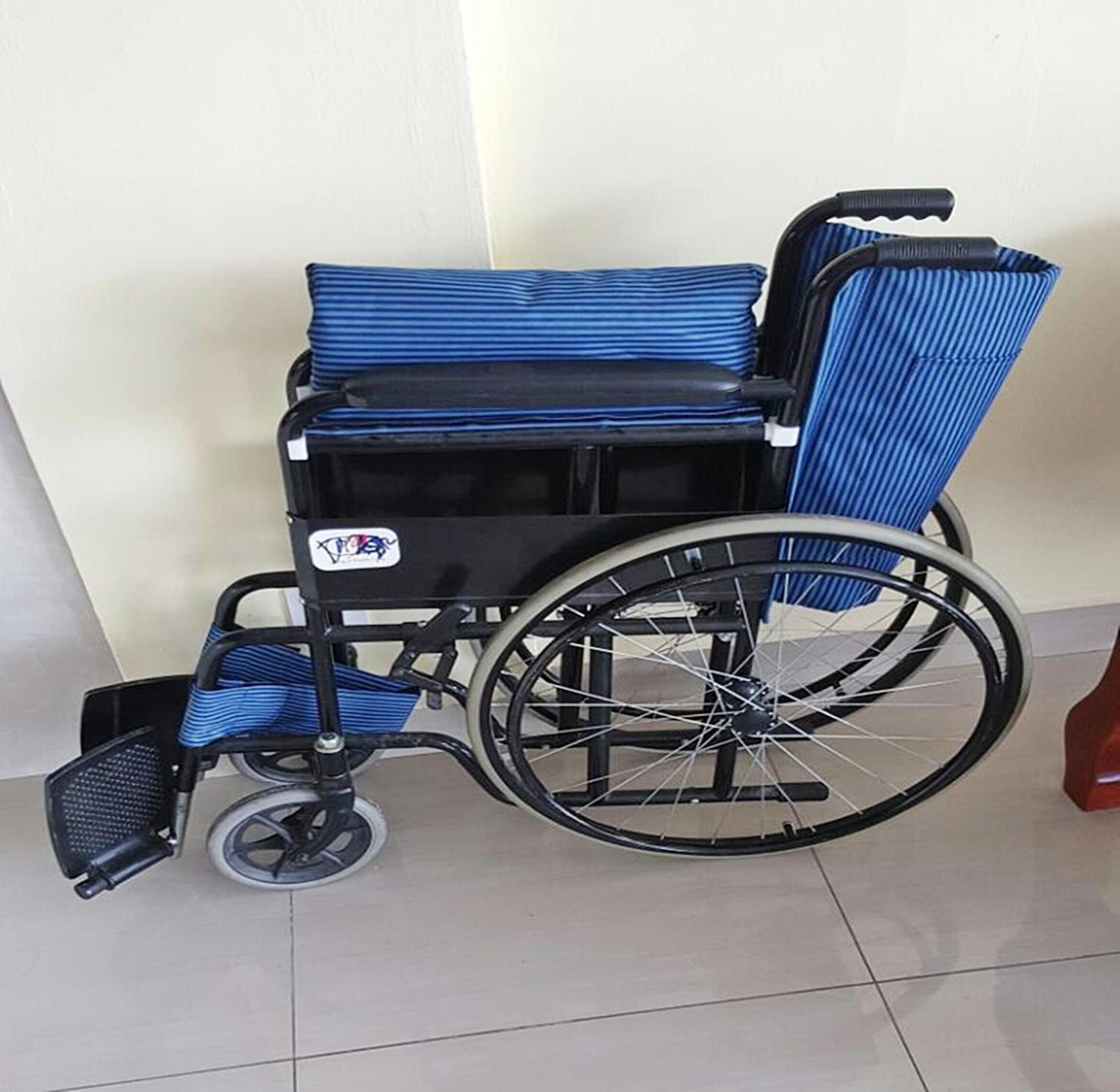 A wheelchair with a blue seat and backrest, a black frame, and a storage compartment.