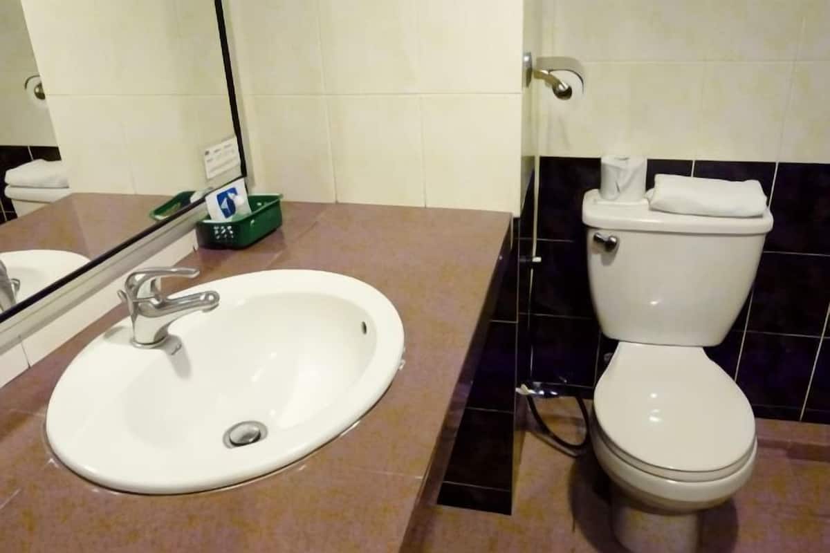 Een douche, pantoffels, een bidet, handdoeken