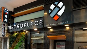 Entrada de hotel com um letreiro 'METROPLACE', número de contato e logotipo.