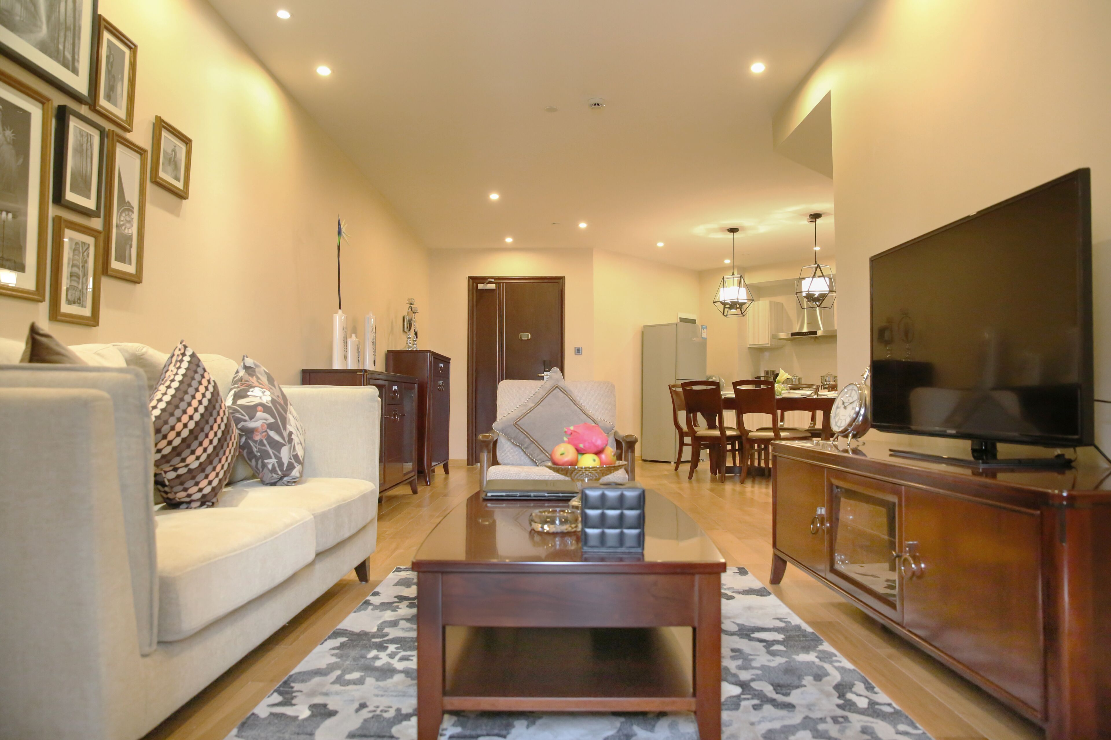 A living room with a sofa, coffee table, TV, and dining area.