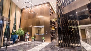 A modern lobby with a reception desk, seating area, and a staircase. - Green Court Residence Jinqiao Diamond Shanghai (Shanghai)