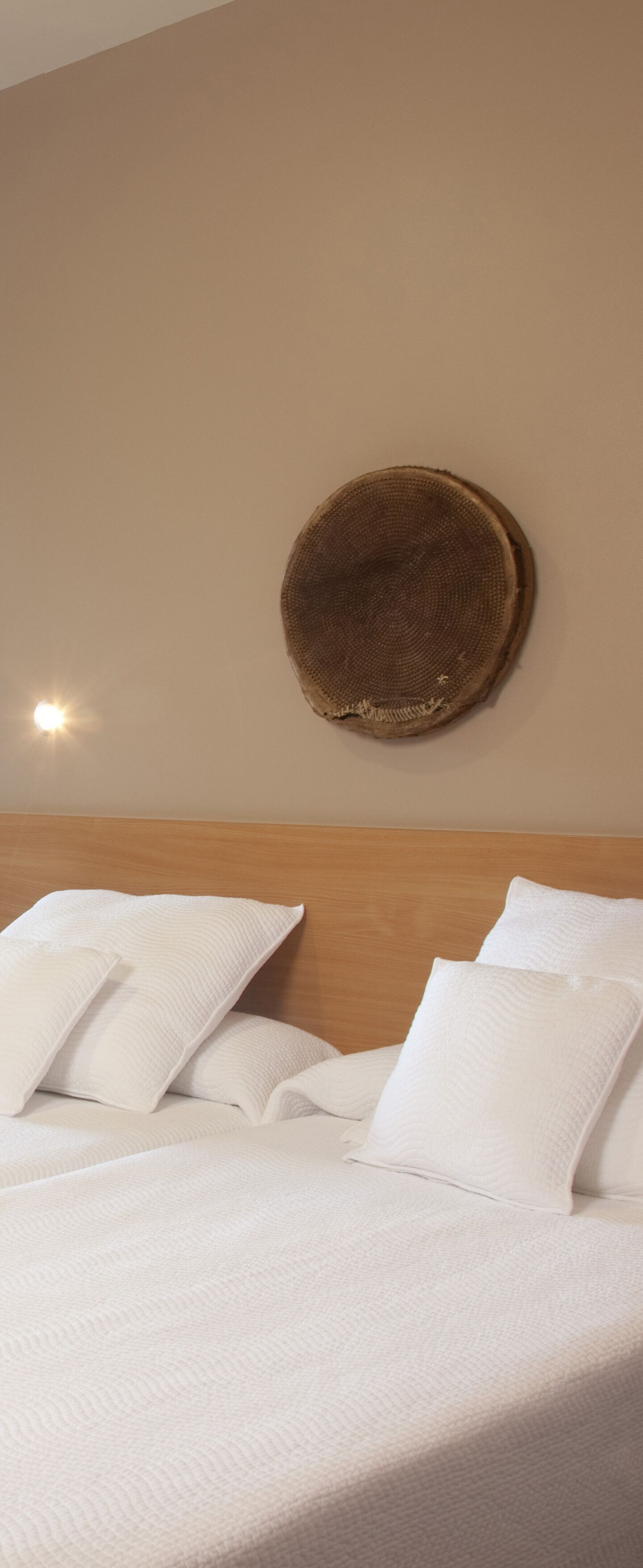 A bed with white bedding and a wooden headboard.