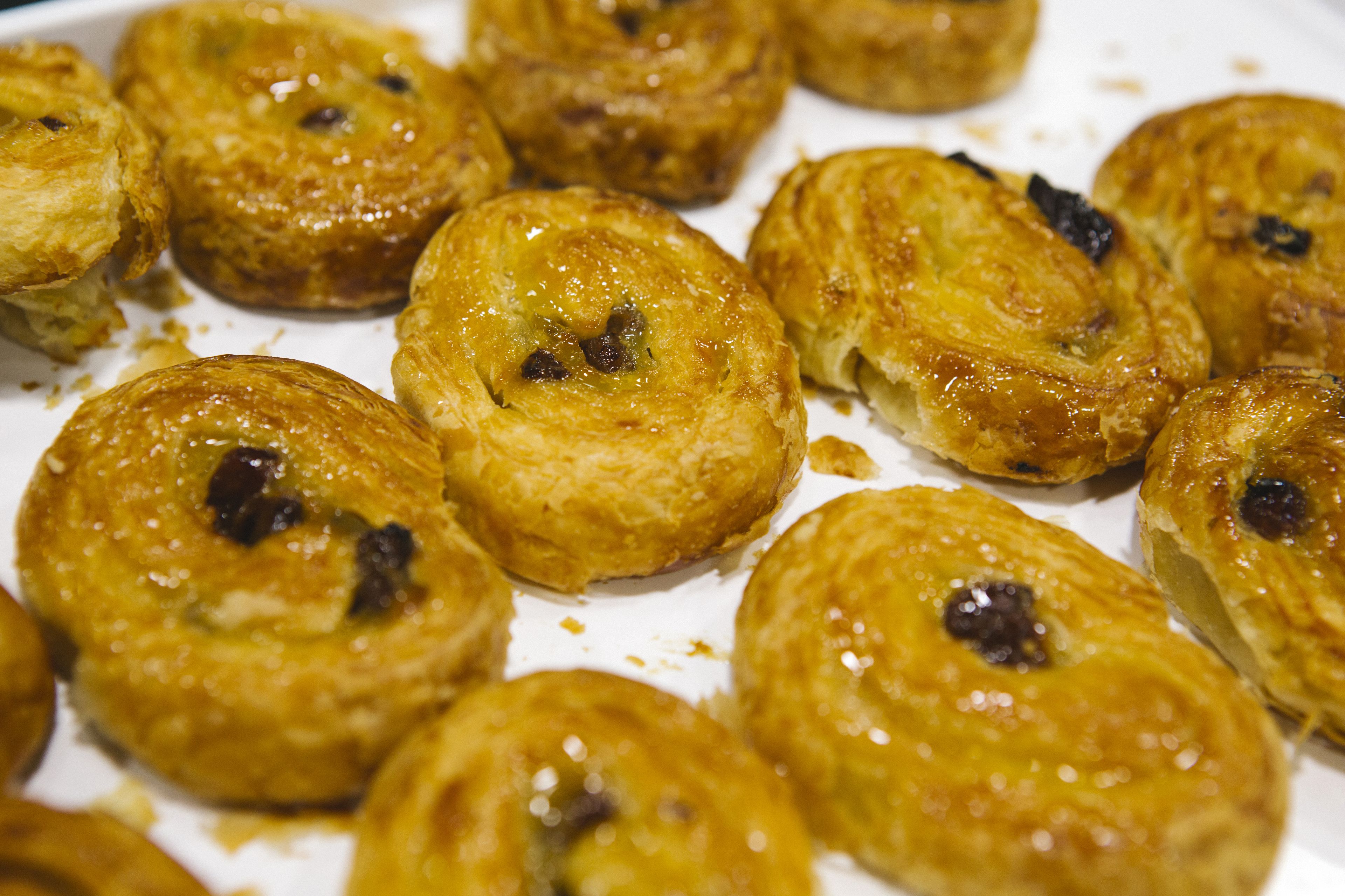A close-up of round pastries with a golden-brown crust and visible dark filling.