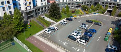 A multi-story residential building with a parking lot.