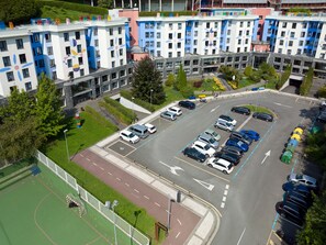 Ein mehrstöckiges Wohngebäude mit Parkplatz.