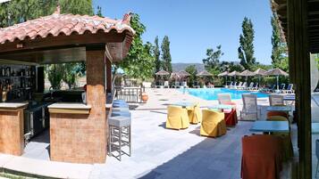 A poolside area with a bar, lounge chairs, and umbrellas.