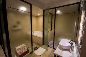 Une salle de bain moderne équipée d’une baignoire, d’un lavabo et d’un espace douche.