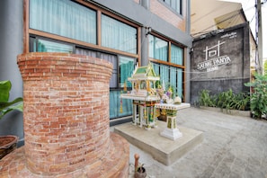 A courtyard with a traditional Thai shrine, a brick column, and a sign for 'Saeng Panya Home'. - Saengpanya Home Boutique Hotel - SHA Plus  (Chiang Mai)