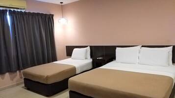 A hotel room with two beds, a nightstand, a lamp, and a window with curtains.