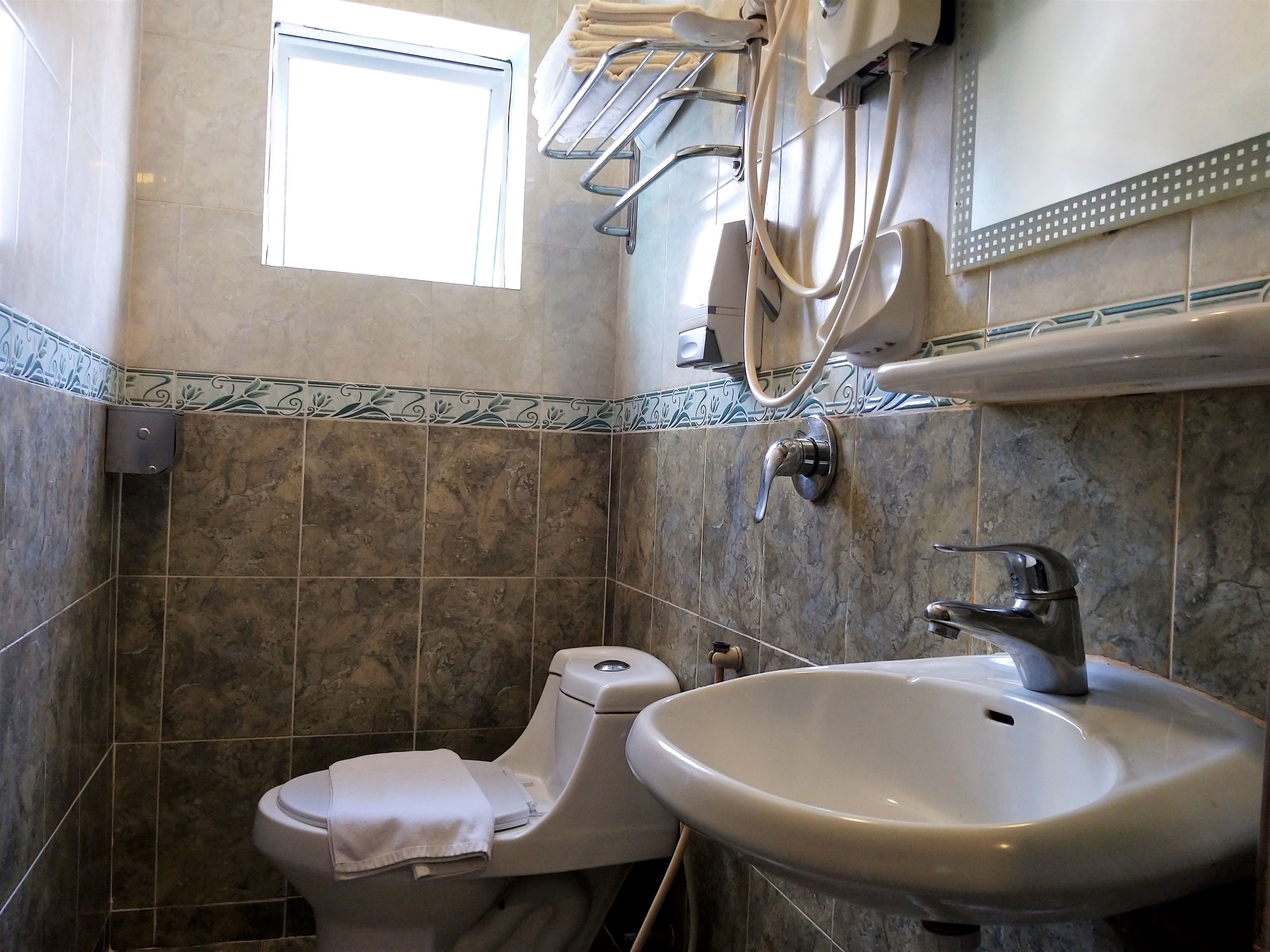 A bathroom with a toilet, sink, and towel rack.