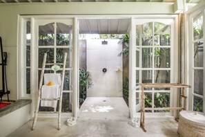 A room with a large window, a ladder, and a small table. - Villa Lodek Deluxe (Seminyak)