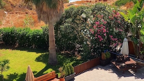 A pool area with a view of the ocean, surrounded by greenery and a wooden deck. - Kanalli Restaurant & Apartments (Pomos)