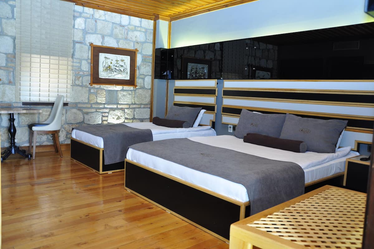 A hotel room with two beds, a desk, and a chair.