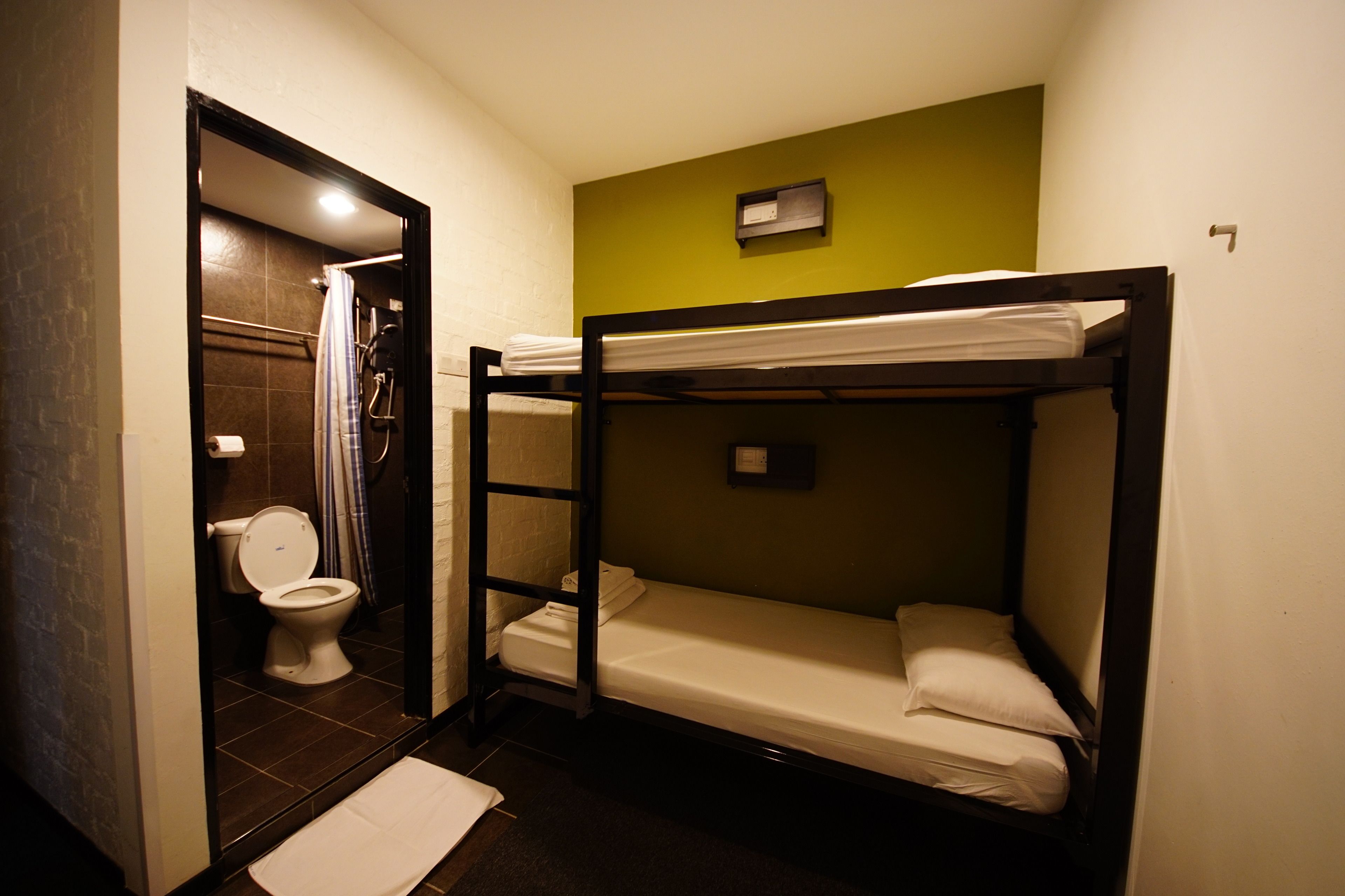 A small, compact room with a bunk bed, a toilet, and a shower area.