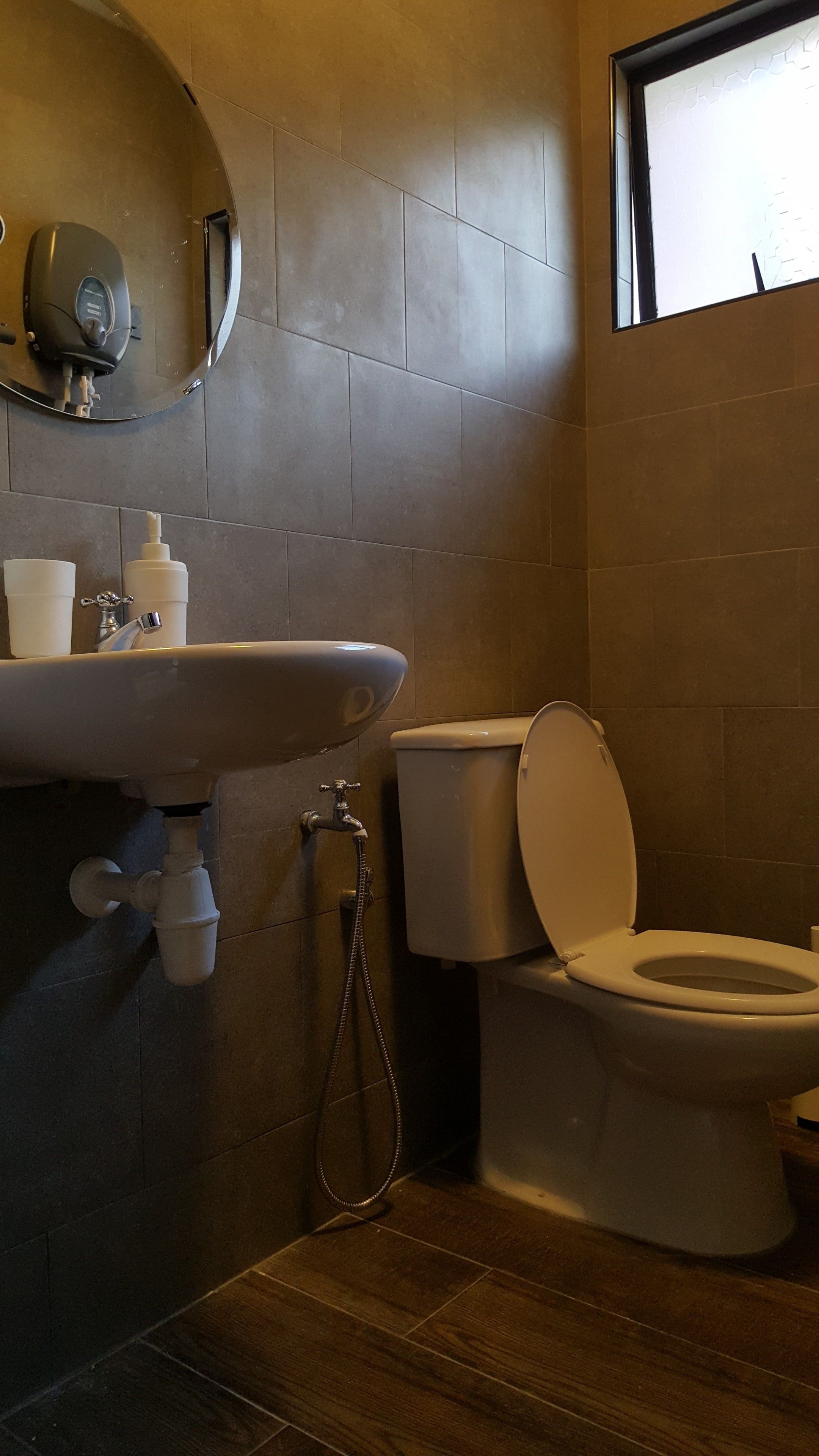 A bathroom with a sink, toilet, and a mirror.