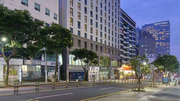 Un hôtel de grande hauteur, doté de nombreux étages, d’une architecture moderne et d’une façade bien éclairée.