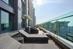 A rooftop terrace with outdoor seating, a glass balustrade, and a city view. - Jeju Central City Hotel (Jeju City)