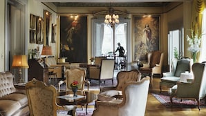 Une vaste pièce agrémentée de lustres somptueux, de meubles classiques et de grands tableaux.