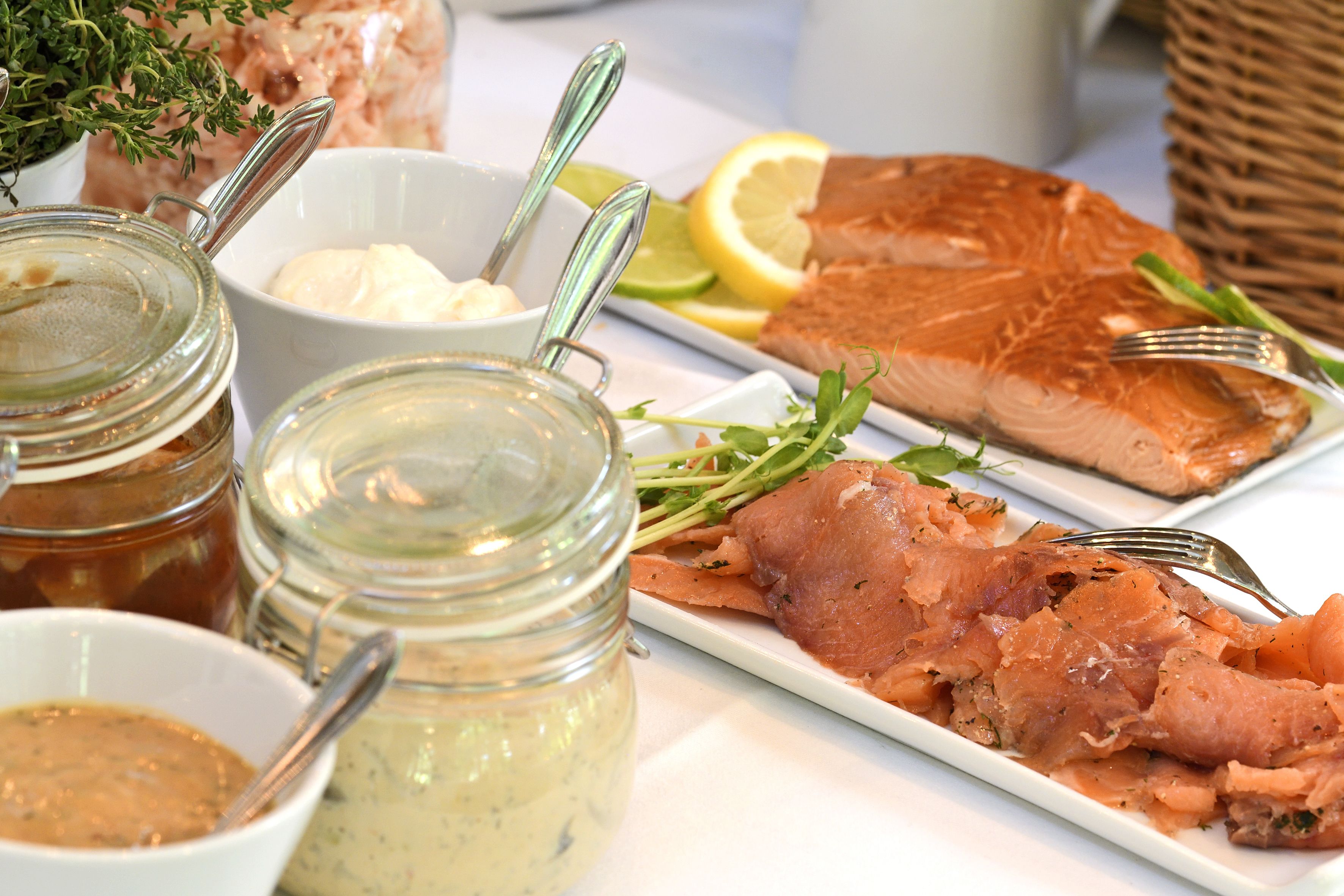 A table with salmon, lemon, and various condiments.