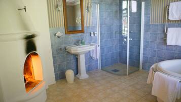 A bathroom with a white sink, mirror, and shower. There is a towel rack and a trash can.
