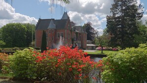 A large, historic building with a prominent tower and a fountain in the foreground. - Thorskogs Slott (Västerlanda)