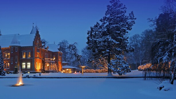 A large, historic building with a snow-covered landscape and a fountain in the foreground. - Thorskogs Slott (Västerlanda)