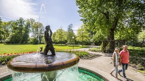 A fountain with a statue in a park with green grass and trees. - Amedia Weiden, Trademark Collection by Wyndham (Weiden in der Oberpfalz)