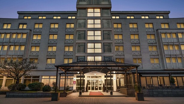 A modern hotel with a central entrance, large windows, and a covered outdoor area. - Amedia Weiden, Trademark Collection by Wyndham (Weiden in der Oberpfalz)