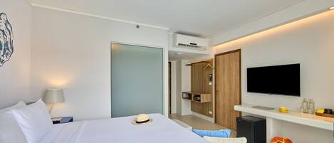 Une chambre d’hôtel moderne équipée d’un lit, d’une télévision, d’un bureau et d’une armoire.