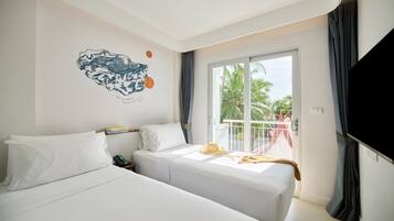 A hotel room with two beds, a large window, and a wall decoration.