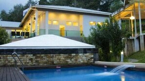 A modern house with a swimming pool, stone walls, and a covered deck area. - Laman Pesona Resort & Spa (Raub)