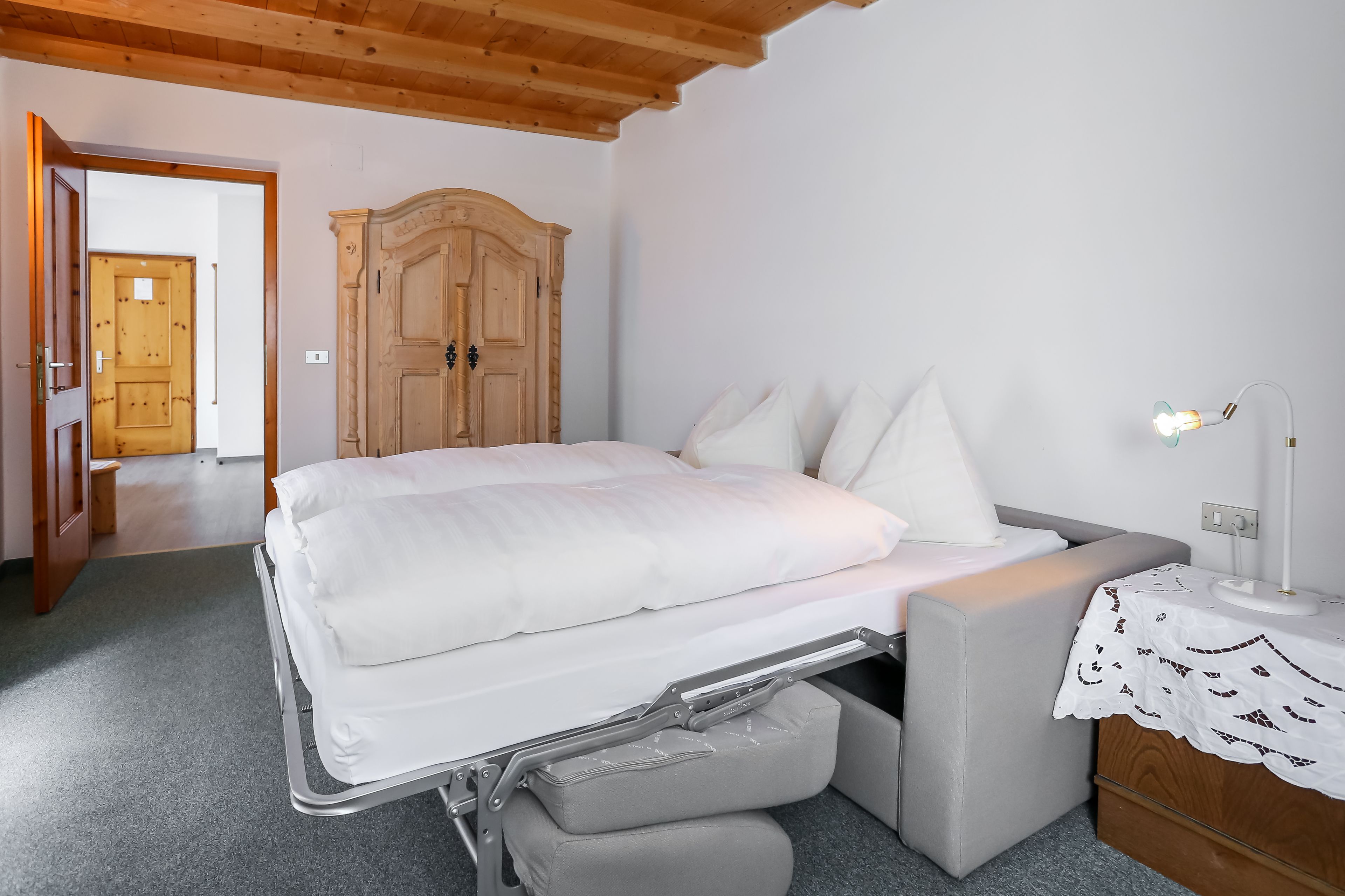 Une chambre à coucher avec un lit, une table de chevet, une lampe et une armoire.