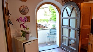 A kitchen with a refrigerator, a potted orchid, and a clock on the wall. - Garni Meinrad (Ora)