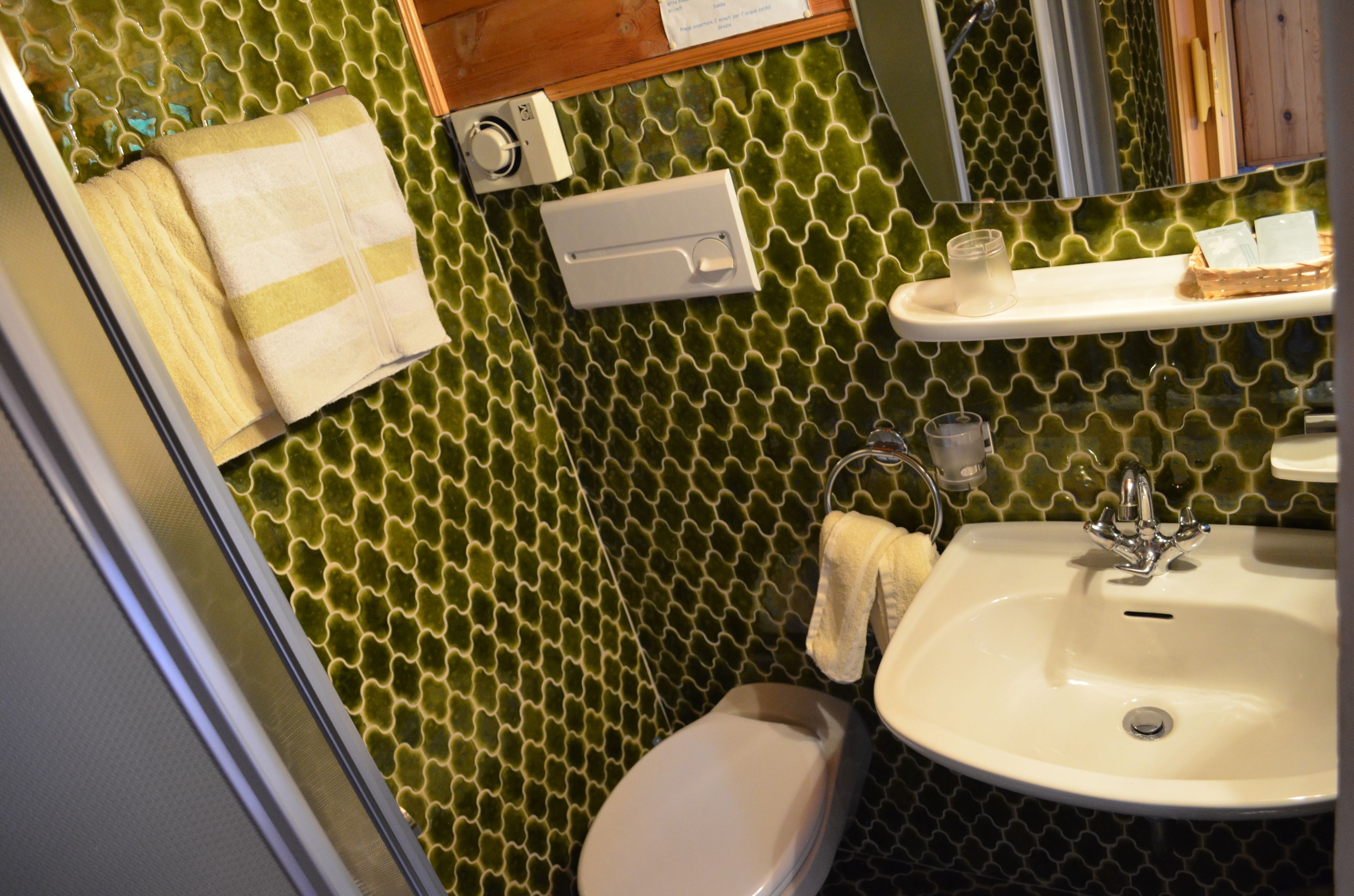 A bathroom with a toilet, sink, and towel rack.