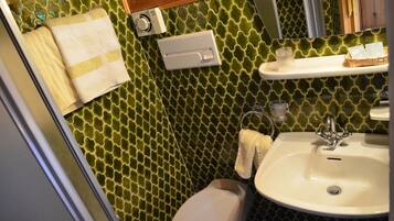 A bathroom with a toilet, sink, and towel rack.