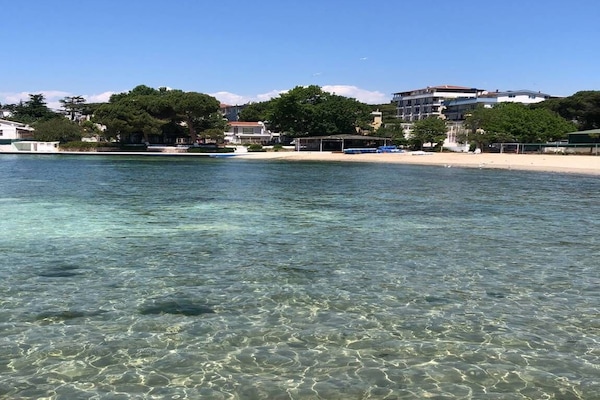Privat strand i nærheten, hvit sand, solsenger og parasoller