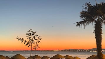 Privéstrand vlakbij, wit zand, ligstoelen aan het strand, parasols