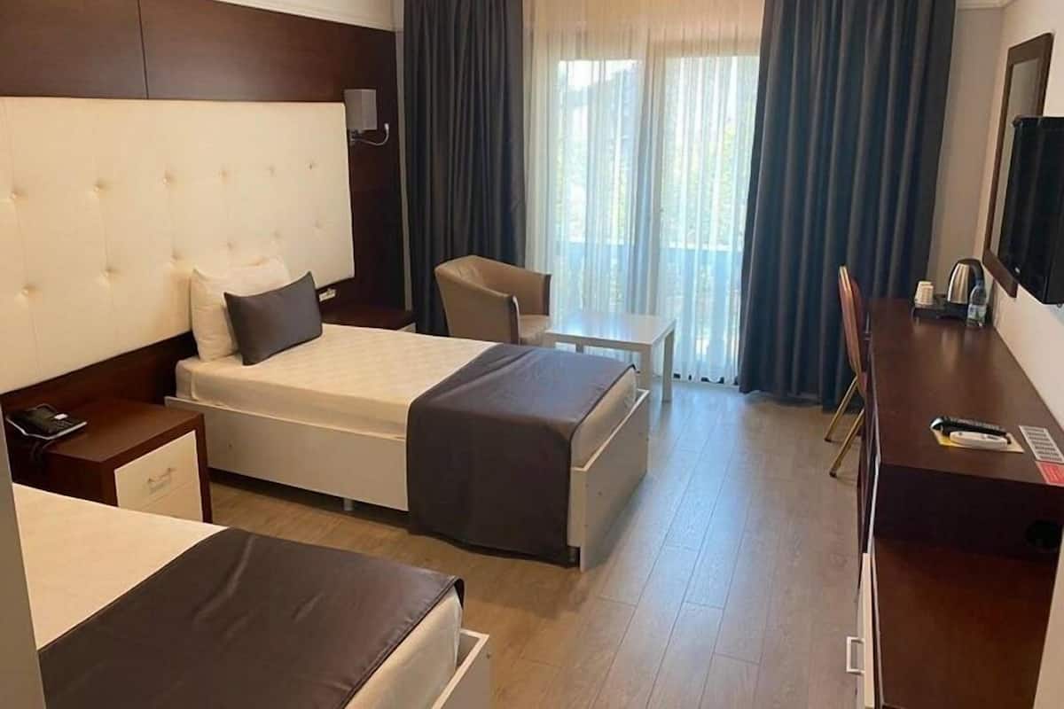 Une chambre d’hôtel avec un grand lit, un bureau, une chaise et un téléviseur.