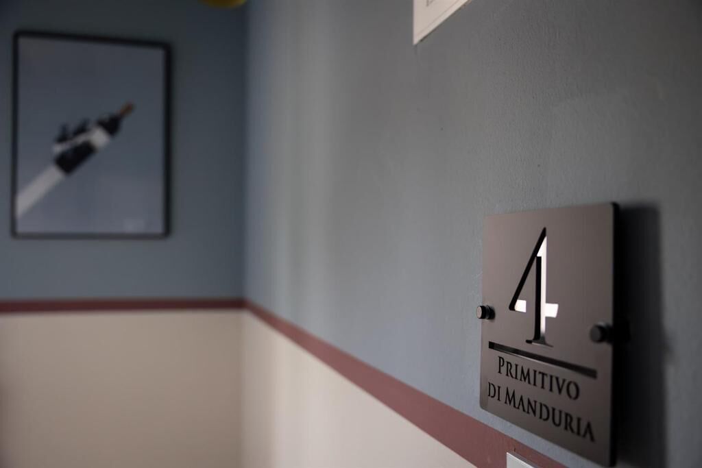 A hallway with a sign reading 'Primitivo di Manduria' and a framed picture on the wall.
