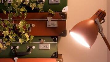 A wall with stacked suitcases and a desk lamp.