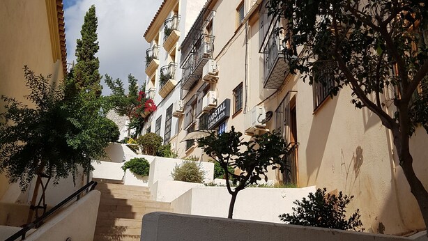 A staircase leading up to a building with balconies and a sign that reads "HOTEL". - Hostal L Escaleta (Oropesa del Mar)