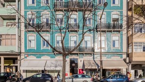 Ein mehrstöckiges Gebäude mit einer markanten blau-weißen Fassade, ausgestattet mit Balkonen und aufwendigen Geländern.