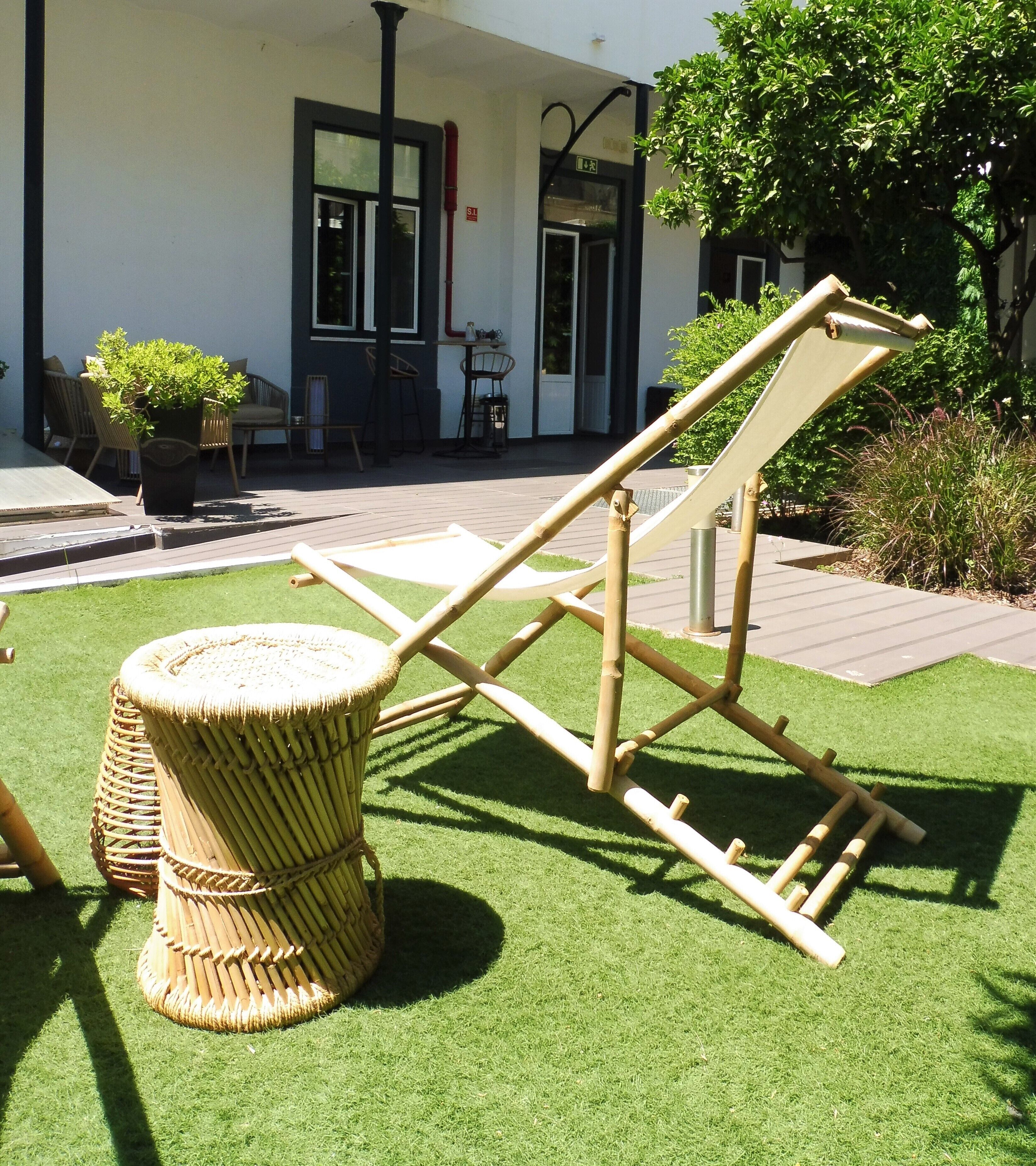 A garden area with a bamboo chair and a woven stool.