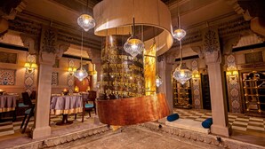 A grand lobby with ornate columns, a large central chandelier, and checkered flooring. - BrijRama Palace, Varanasi - By the Ganges (Varanasi)