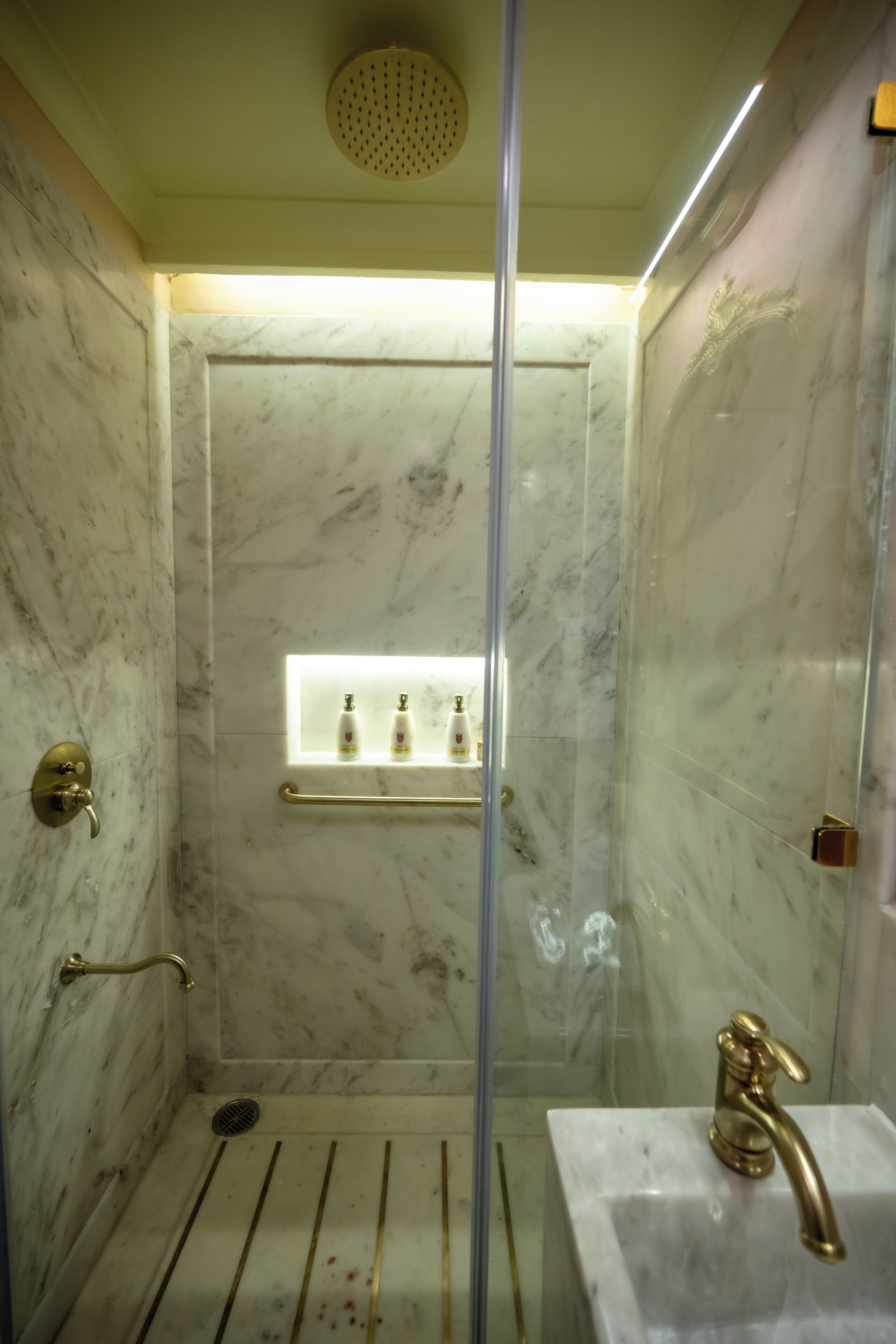 A bathroom with a shower, a sink, and a vanity with a mirror.