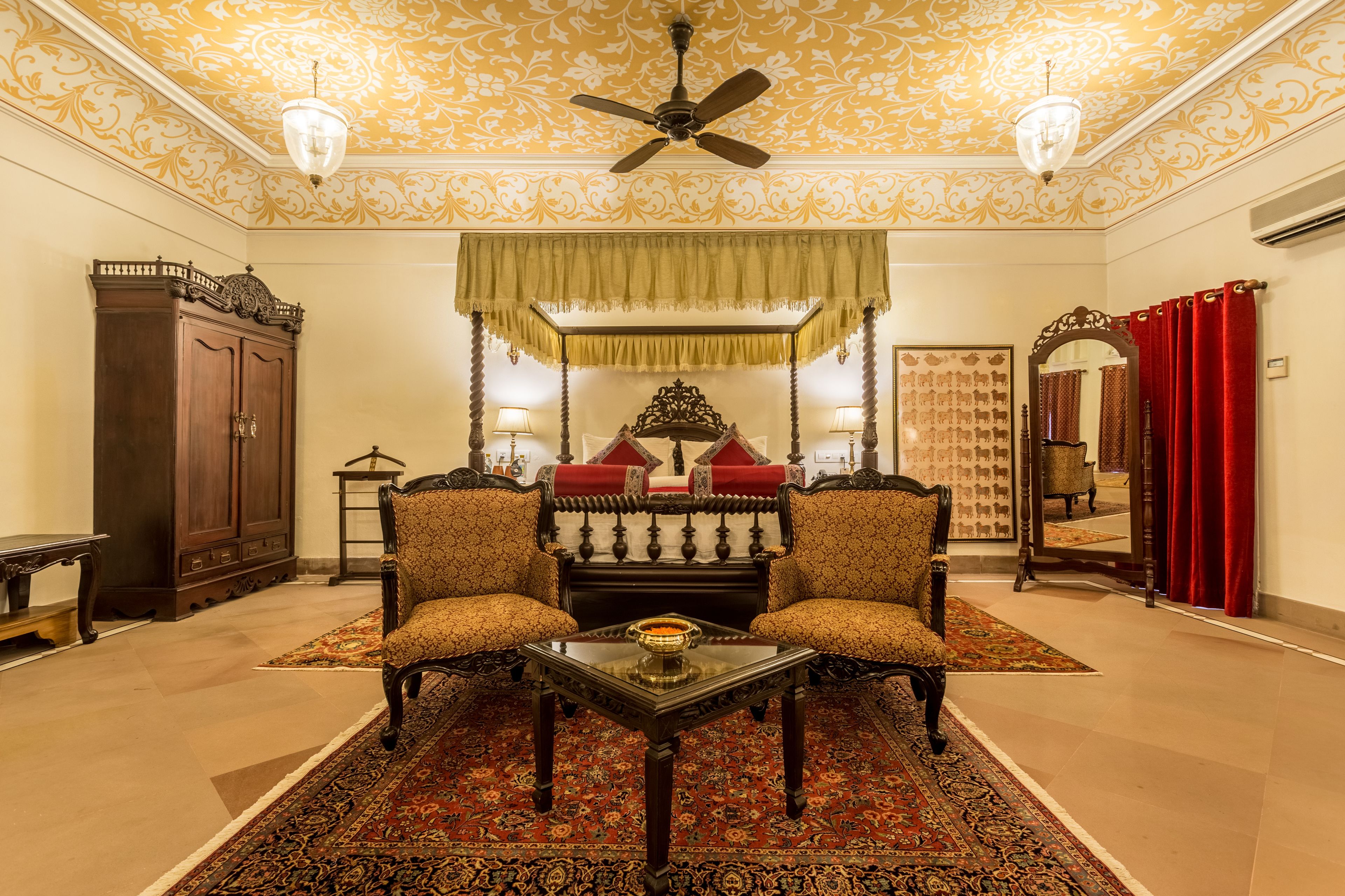 Une pièce de style traditionnel, comprenant un ensemble de canapés, une table, un ventilateur de plafond et des murs à motifs.