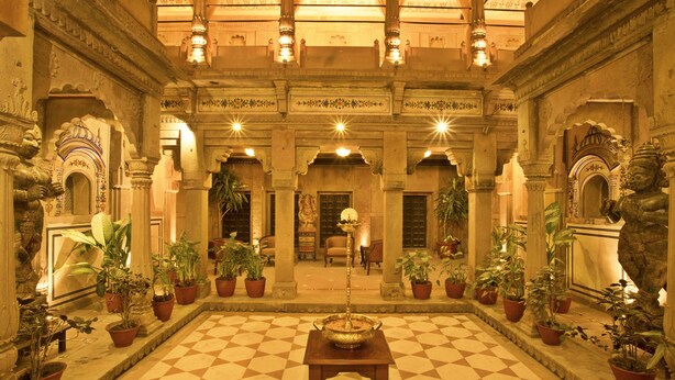 A spacious lobby with a checkered floor, ornate columns, and potted plants. - BrijRama Palace, Varanasi - By the Ganges (Varanasi)