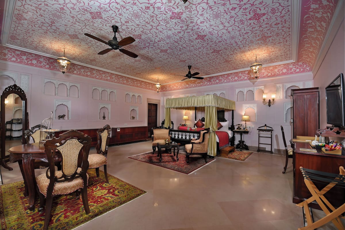 A spacious room with a high ceiling, ornate ceiling design, and multiple seating areas.