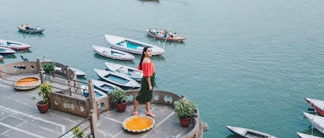 Guests can enjoy serene waterfront views from a platform surrounded by lush greenery and tranquil waters.