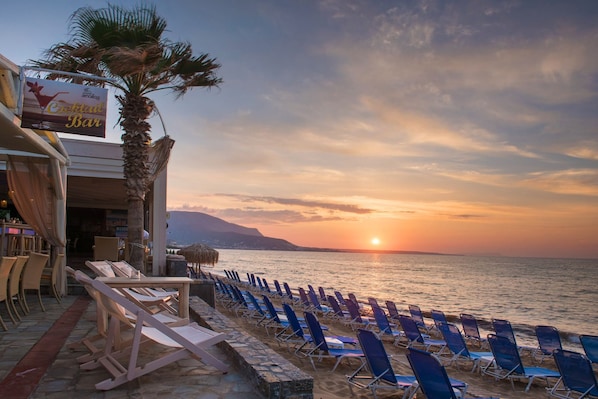 En la playa, sillas reclinables de playa, sombrillas